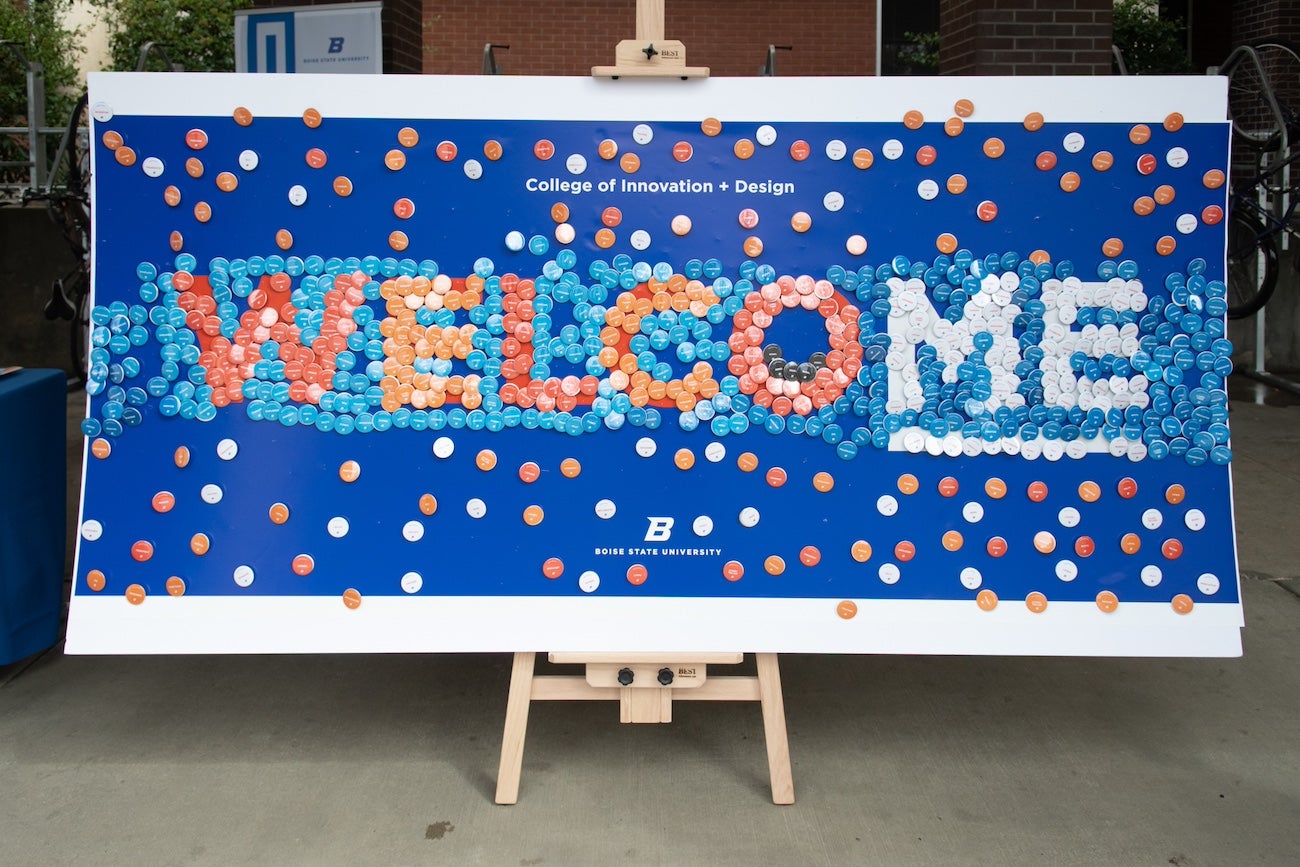 A picture of a button wall that spells "welcome"