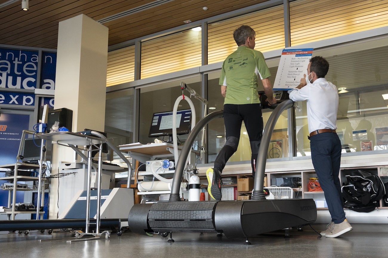 A person instructs a test patient on protocol for endurance treadmill test