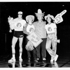 An historical photo of students with hats and pom poms.