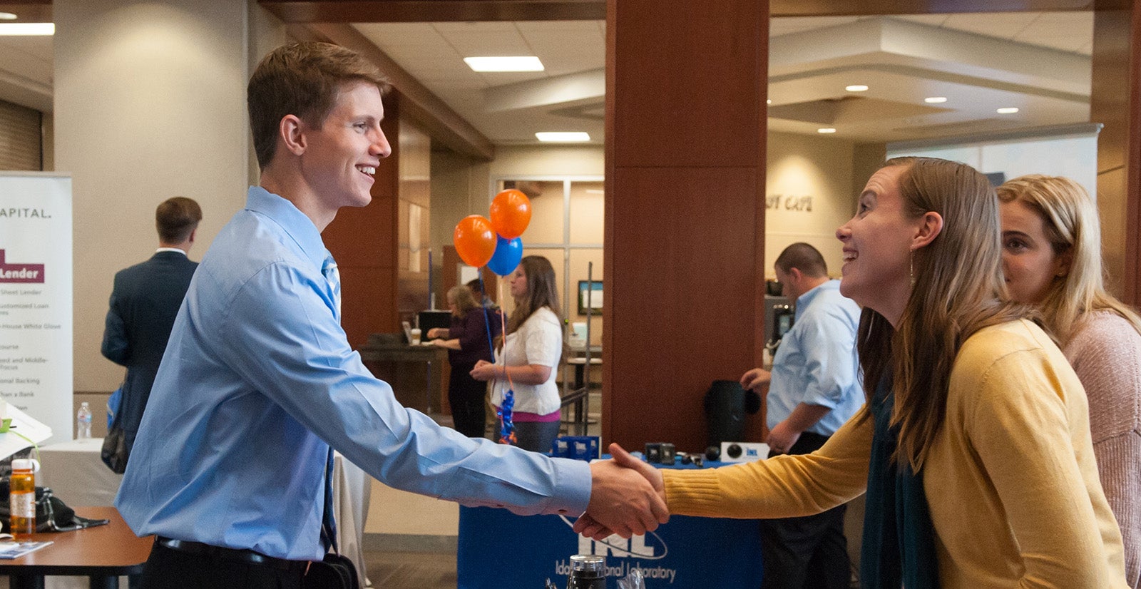 A student shakes hands with an employer at a career fair