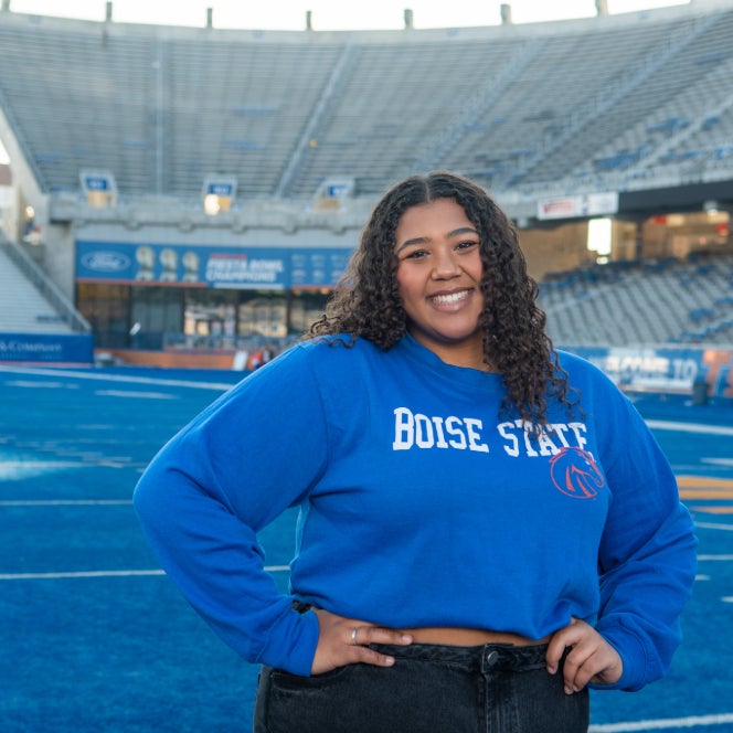 student standing on the blue turf