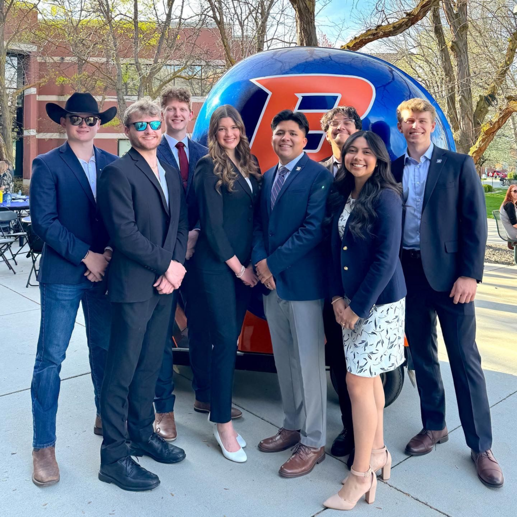 Nick Lloyd standing among fellow ASBSU students in front of a helmet car.