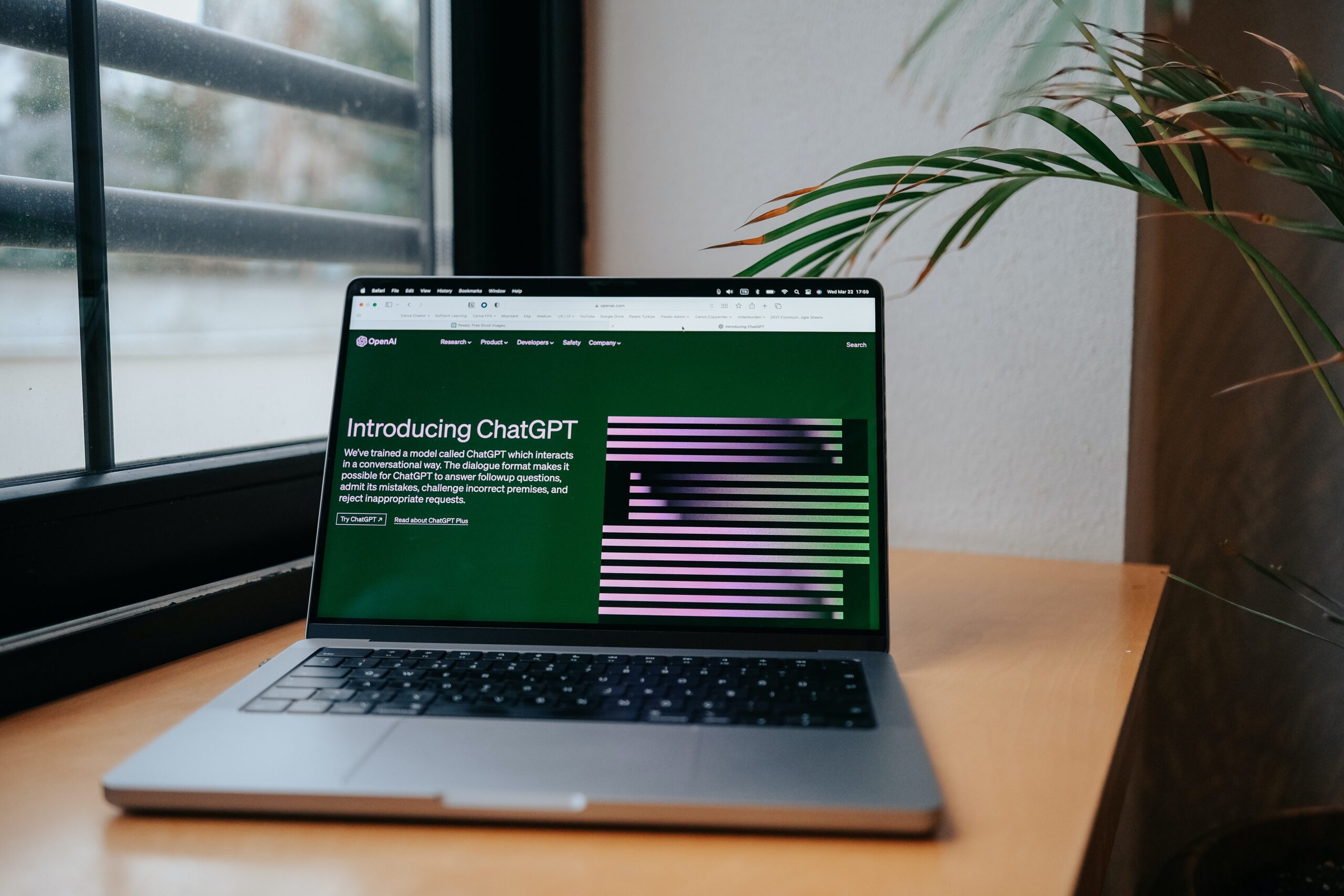 An open laptop rests on a table displaying the opening page to Chat GPT