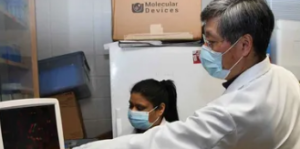 scientists in the lab wearing lab coats and masks