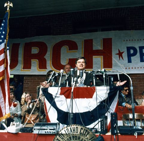 Church speaking at a podium