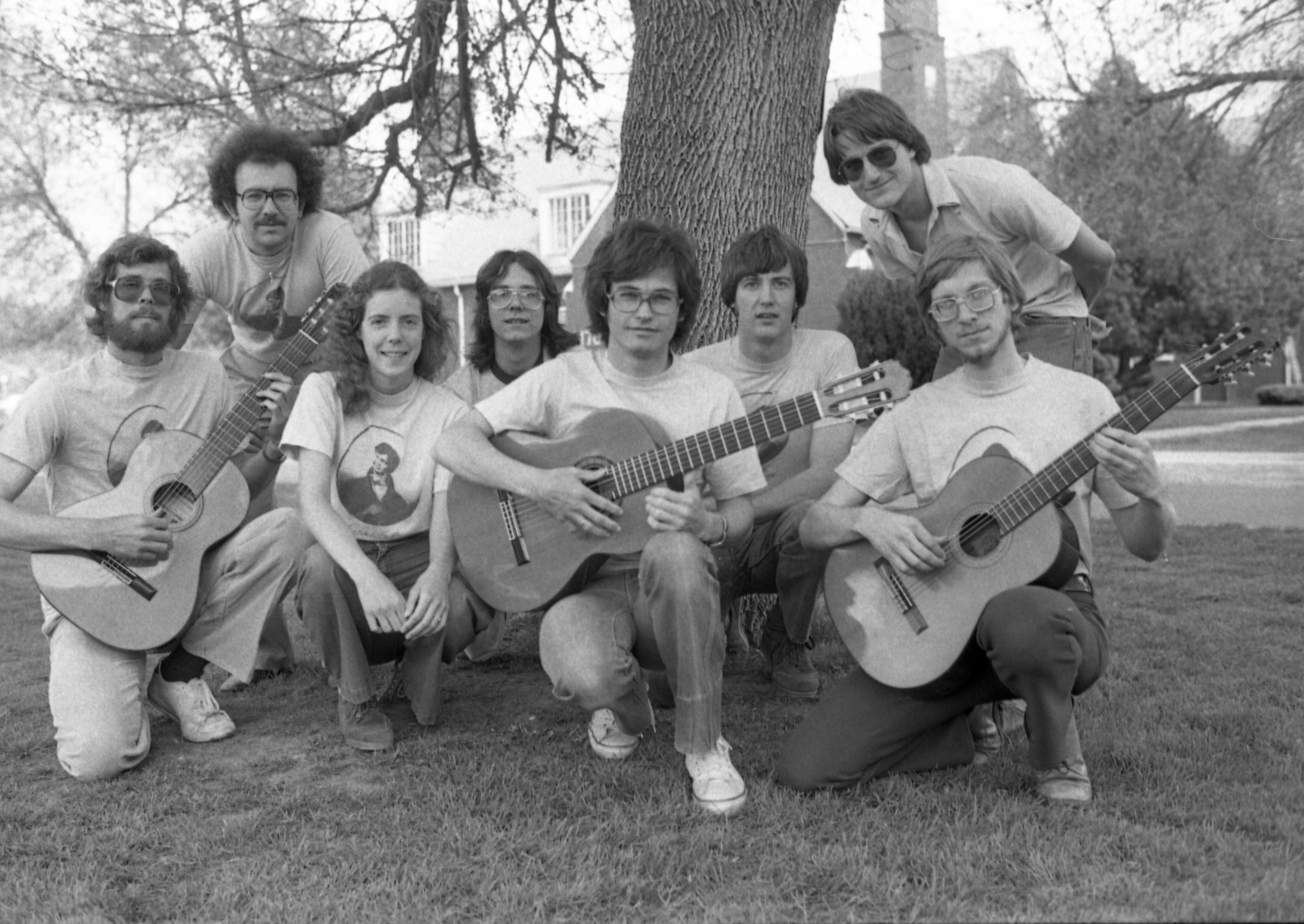 8 Guitar Society members pose for a photo; three are holding guitars