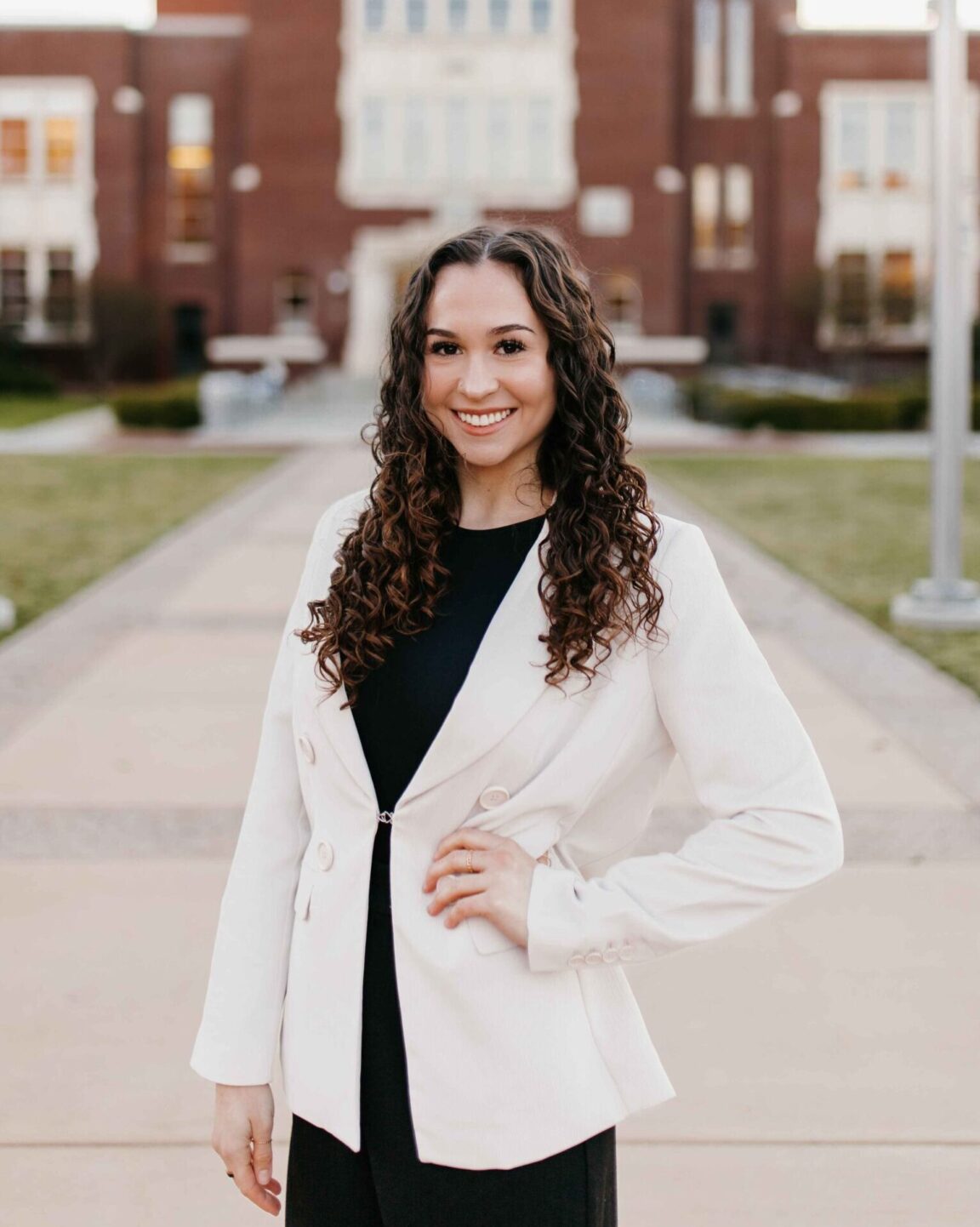 Makena Chase stands in front of a brick building smiling