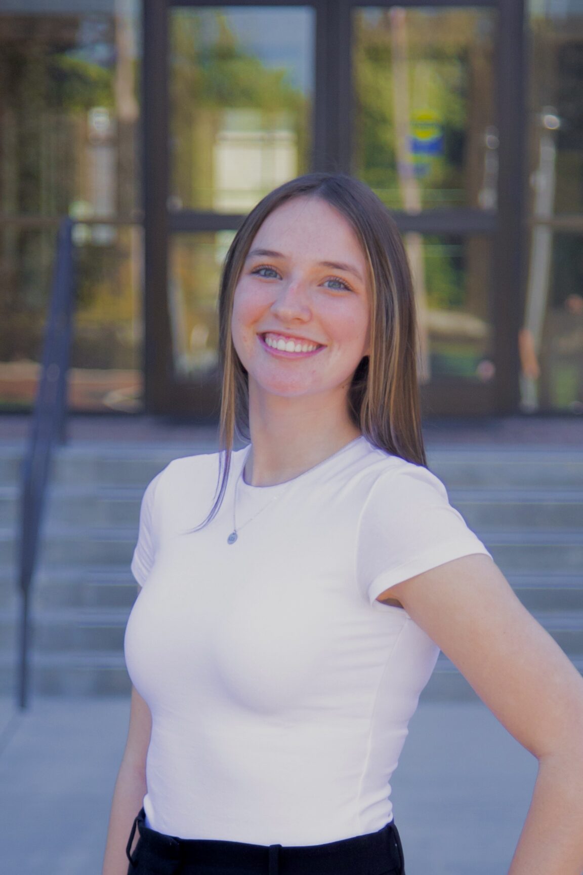 Katie Hettel stands in front of glass doors, smiling