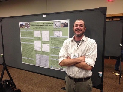 Graduate student in front of poster