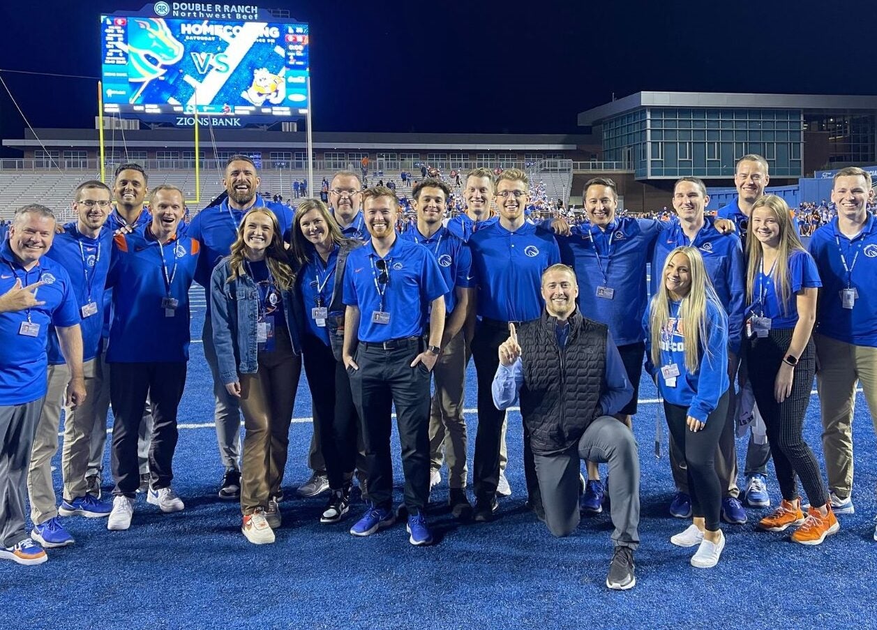 large group of staff and interns posing on the BSU blue field