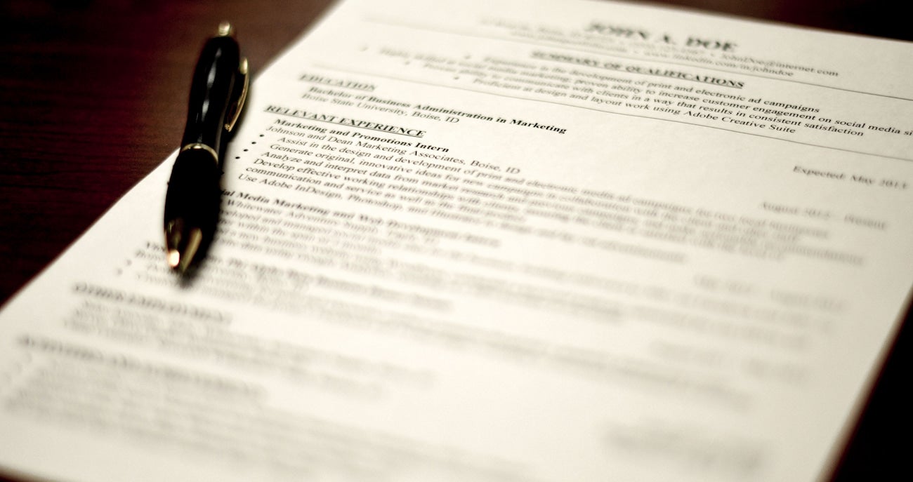 Photo of a resume and pen sitting on a desk