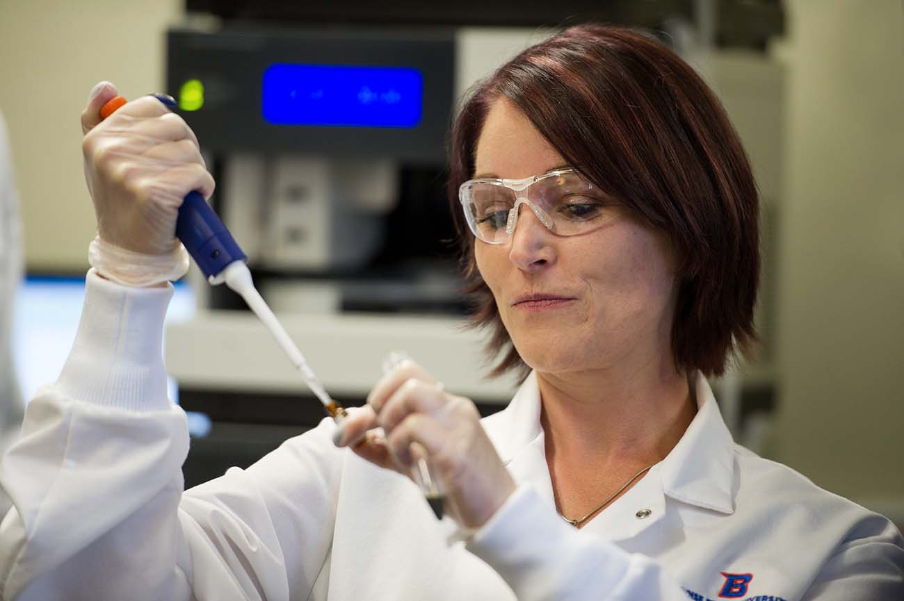 Image of woman working a in lab on graduate research