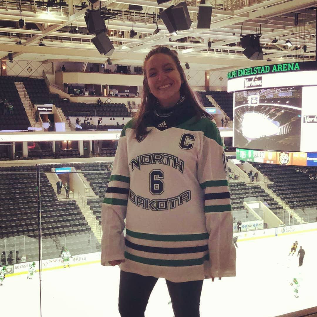 Rachel Reichow standing in arena, wearing a hockey jersey