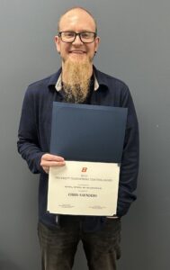 Photo of Chris Saunders holding his UF Teaching Award certificate