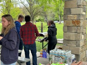 Photo of Oliviero Andreussi and Jenee Cyran standing with a student in front of a portable pizza oven