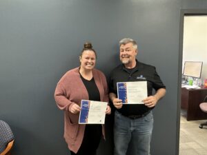 Photo of Kathleen Mukengezi (left) and Sean Ruettgers (right) holding their Years of Service Award certificates