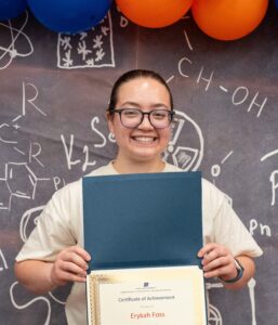 Photo of Erykah Foss holding her URCA scholarship award certificate