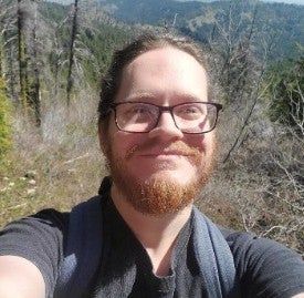 Selfie of James Jenson standing outside with trees in the background