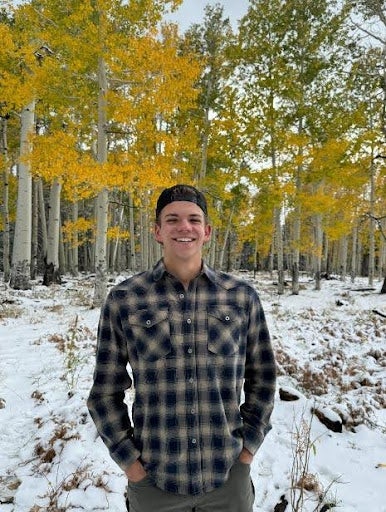 Photo of Jonas Milton standing outside with snow and trees in the background