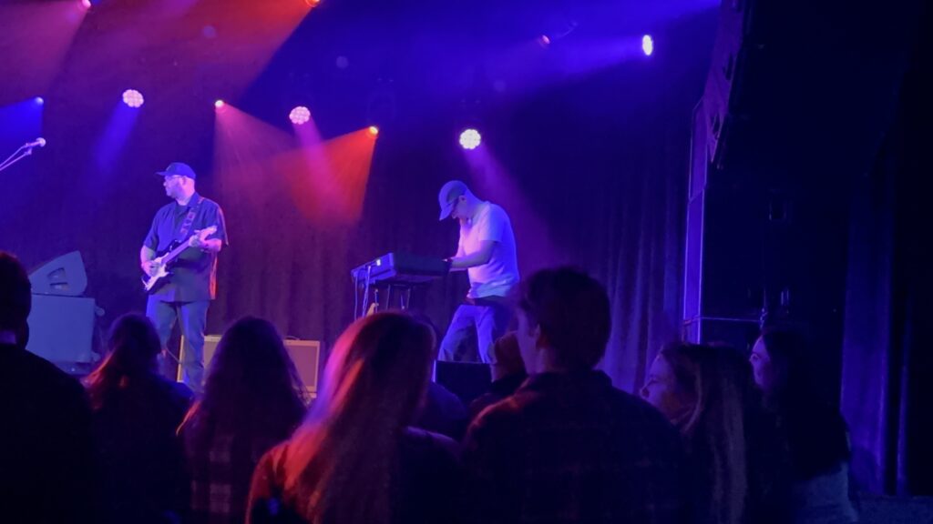 Photo of Chris Saunders on stage playing a keyboard