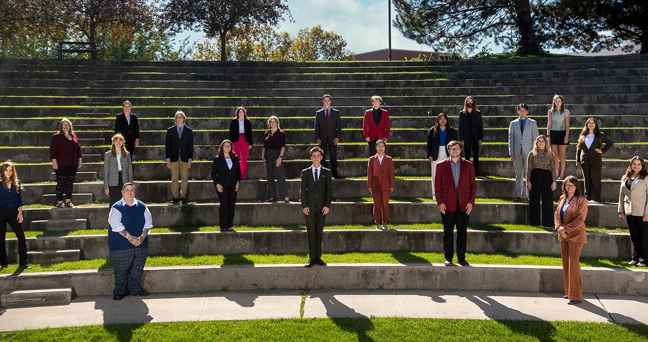 Members of the 2023-2024 Talkin Bronco speech and debate team pose for a photo outside in the Boise State Ampitheater
