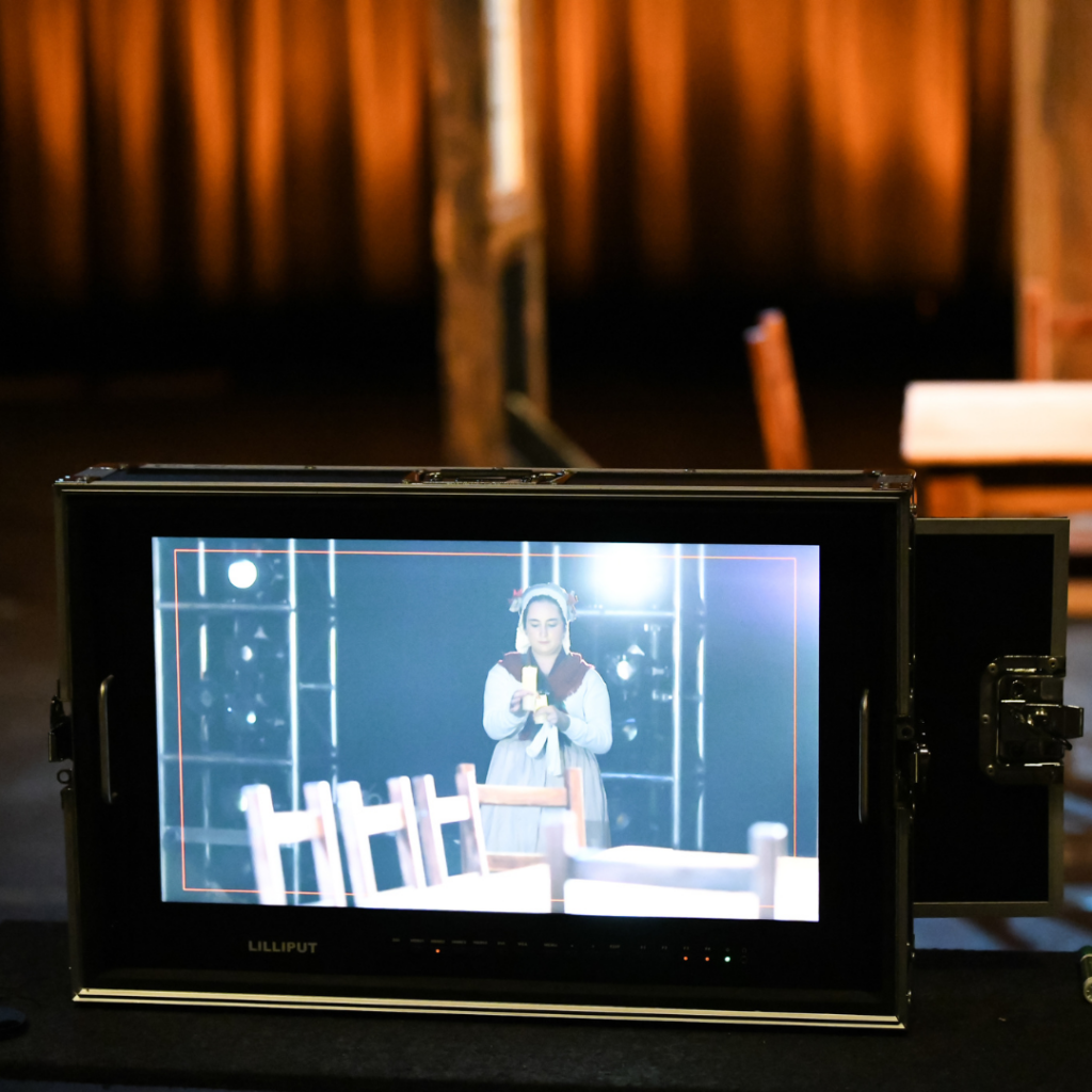 A camera monitor pointed at a student actor