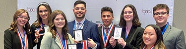 students hold up awards from an accounting competition