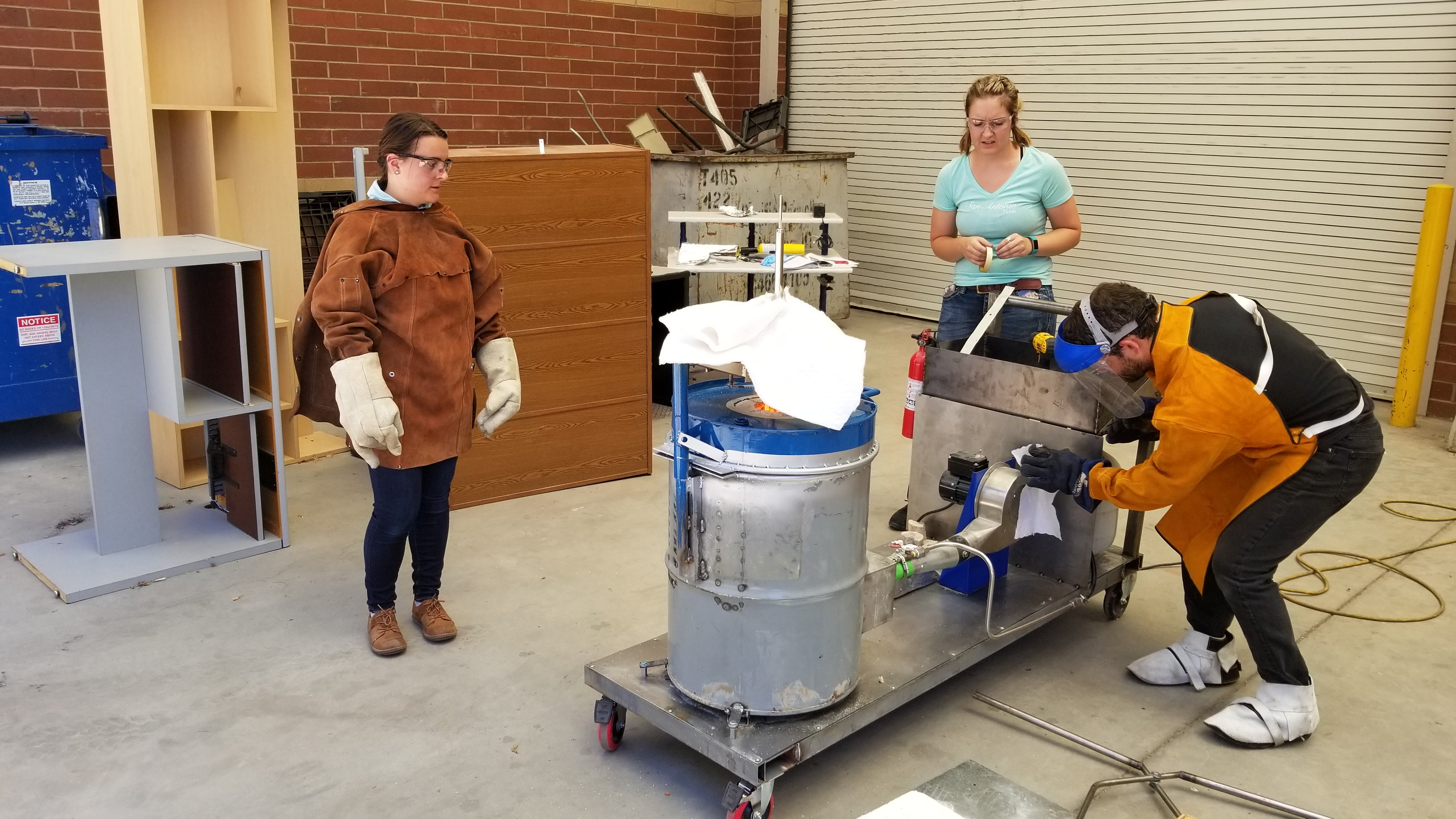 3 people in lab with aluminum cask