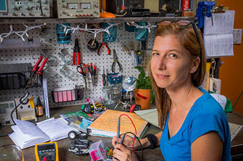 Jen Kniss at a workbench filled with tools