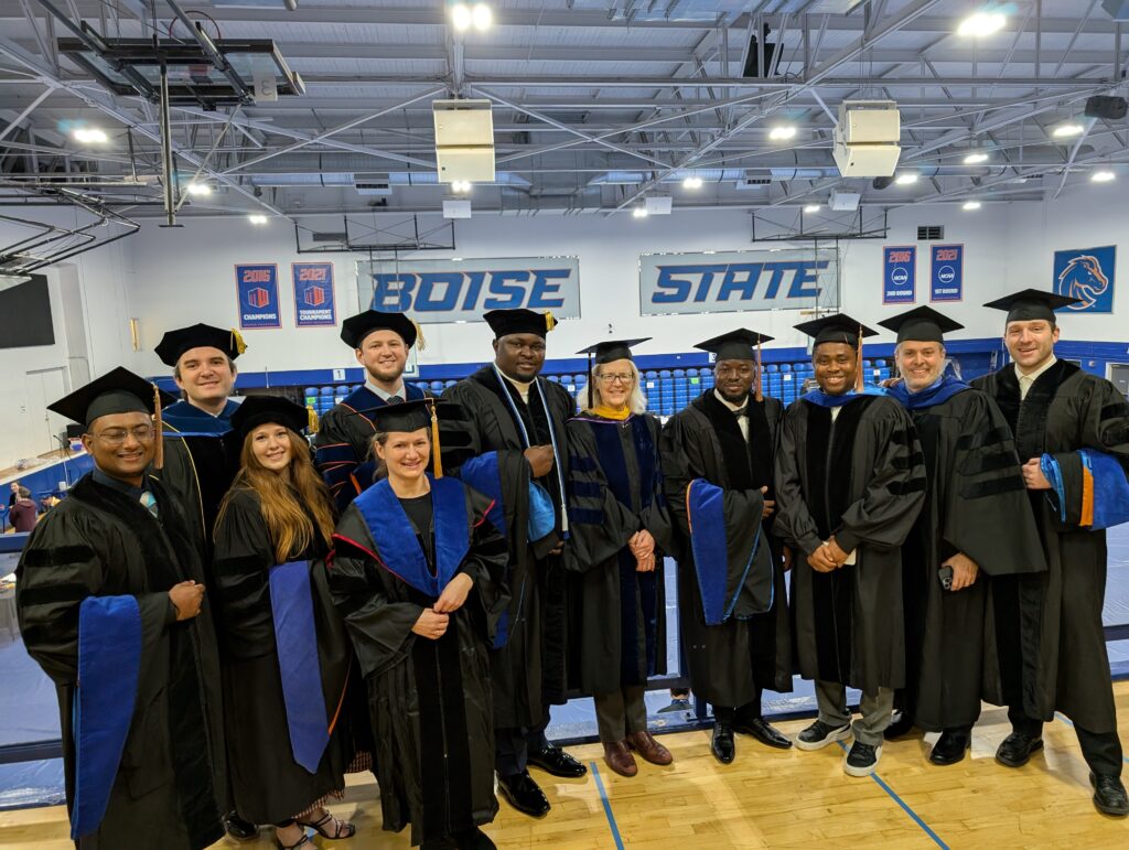 Photo of group of Computing PhD graduates and advisors in the Bronco Gym