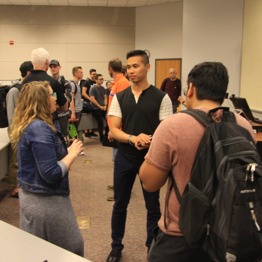 students speaking with a seminar speaker