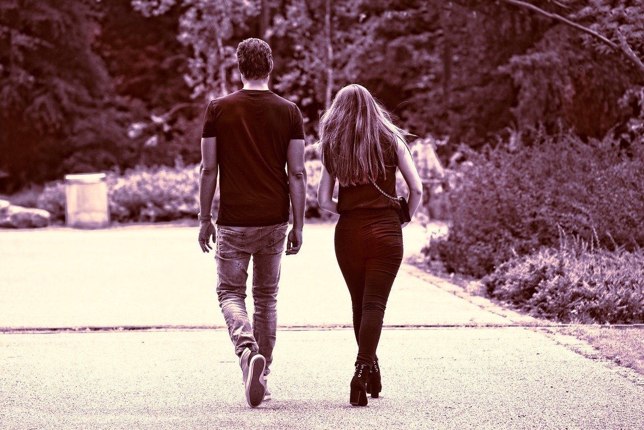 man and woman walking down a path