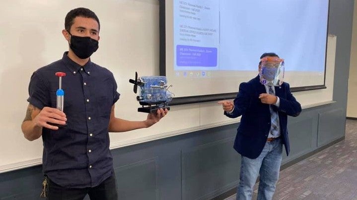 Mechanical and Biomedical Engineering students holding equipment in a classroom