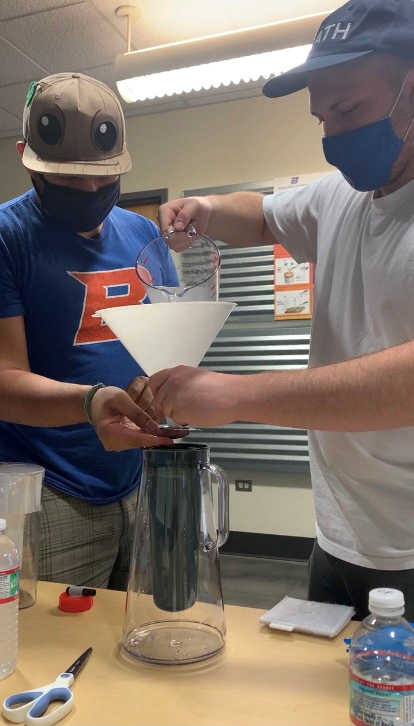 students pouring water through a filtering pitcher