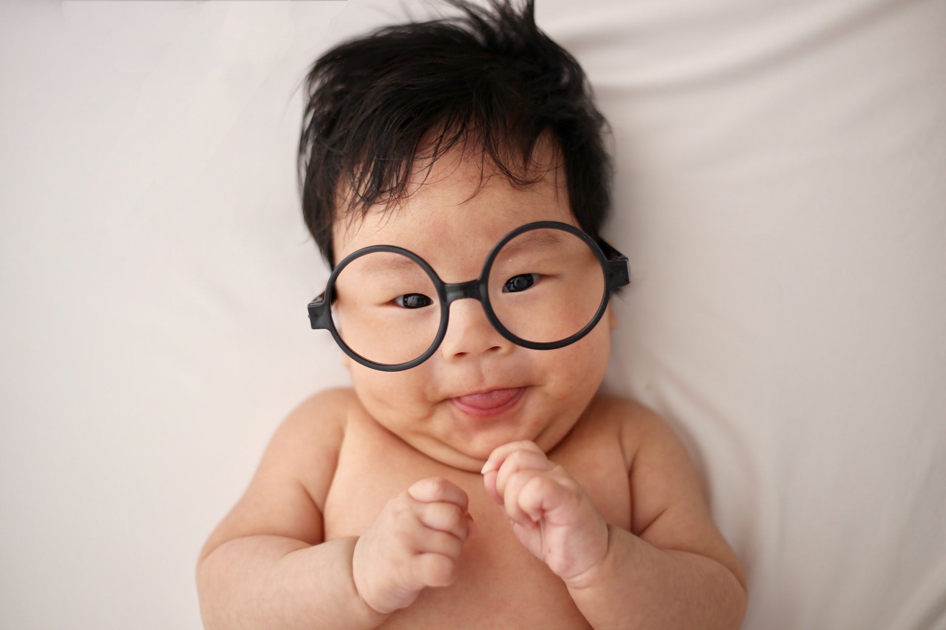 Happy infant wearing big round glasses