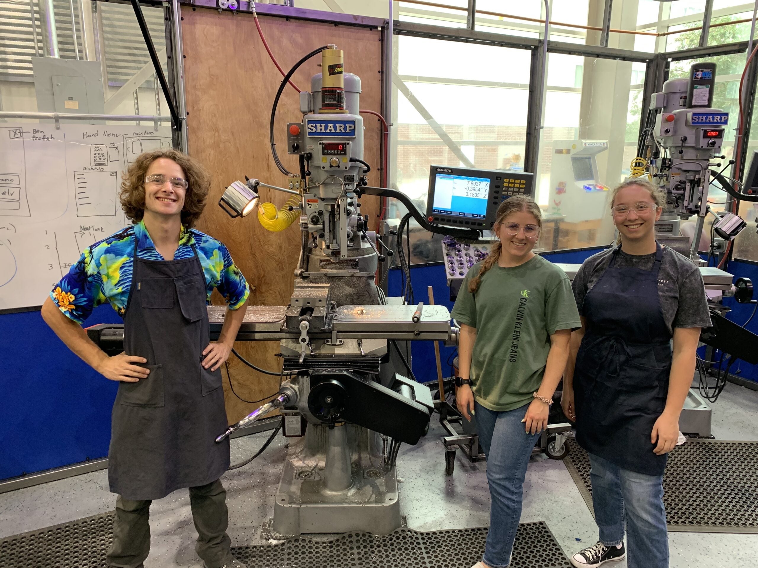 Three students stand next to equipment in studio\Blu