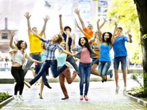 a group of kids jumping with their arms in the air and posing for a photo