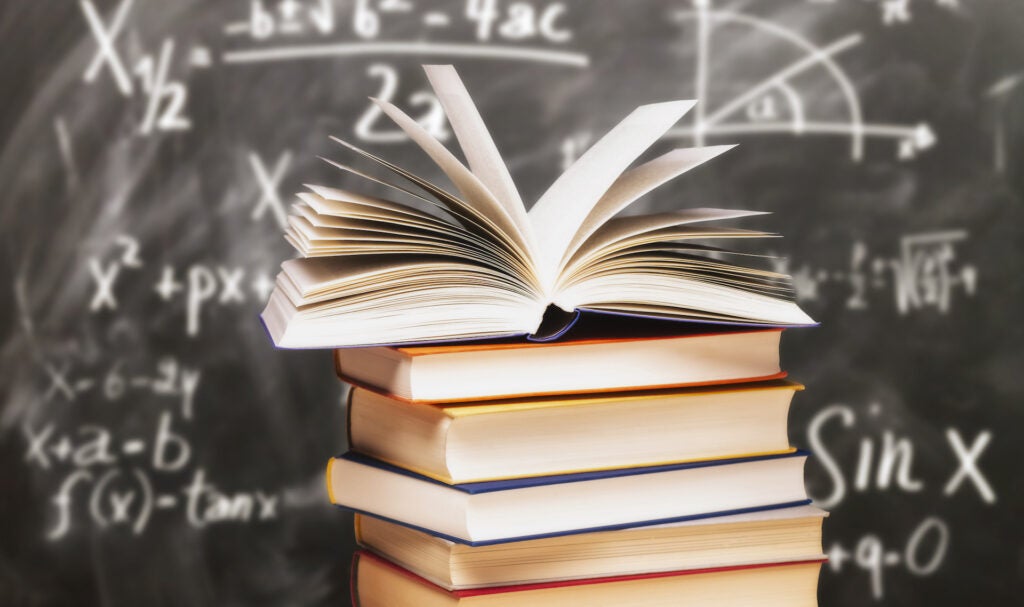 Stack of books in front of a blackboard