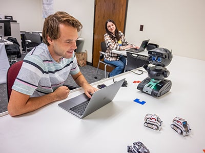 Computer science students working together to build a robot