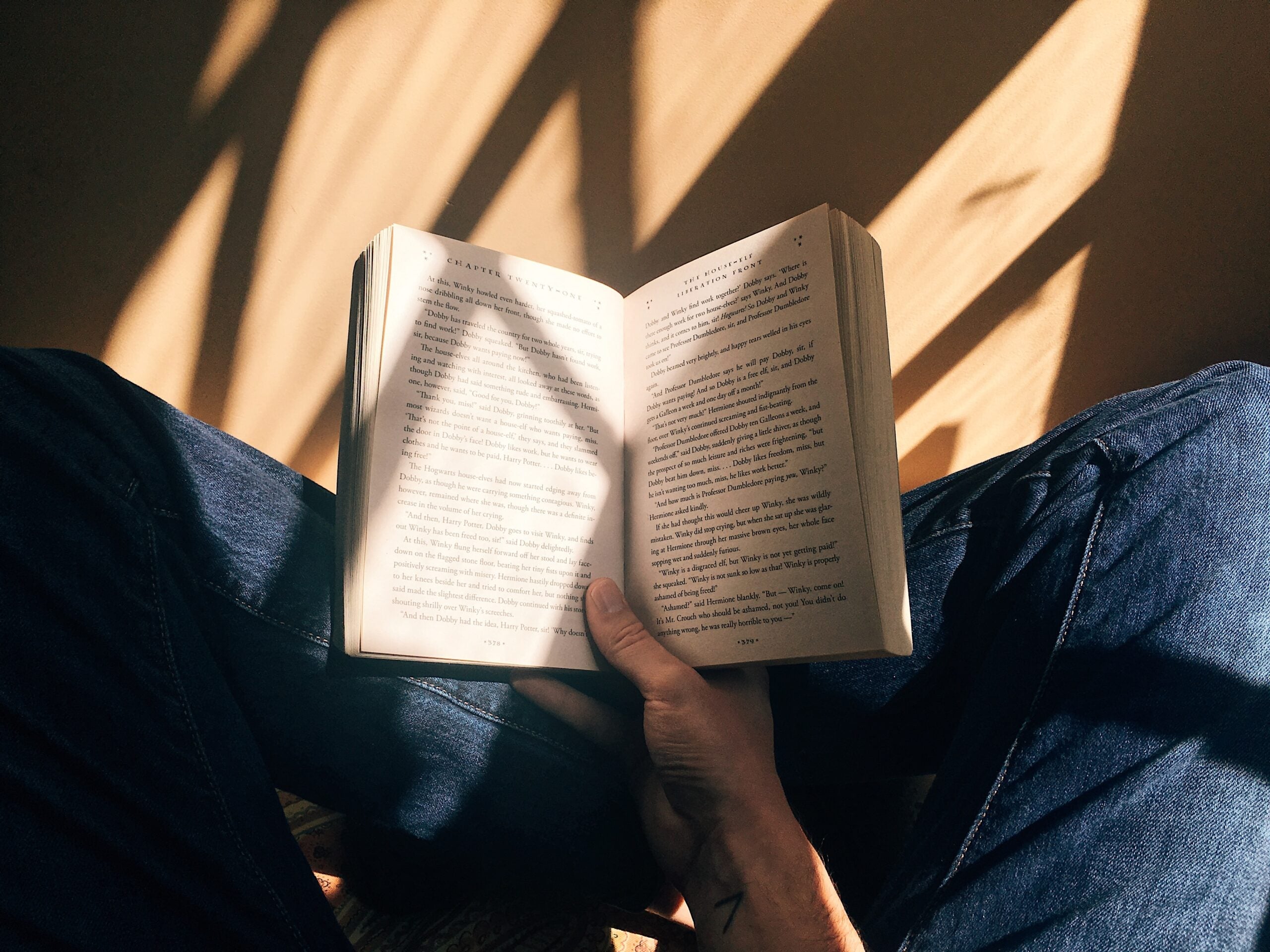 Person sits on the floor reading a book