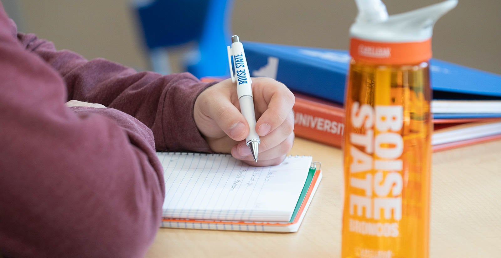Student writes on Boise State branded material 