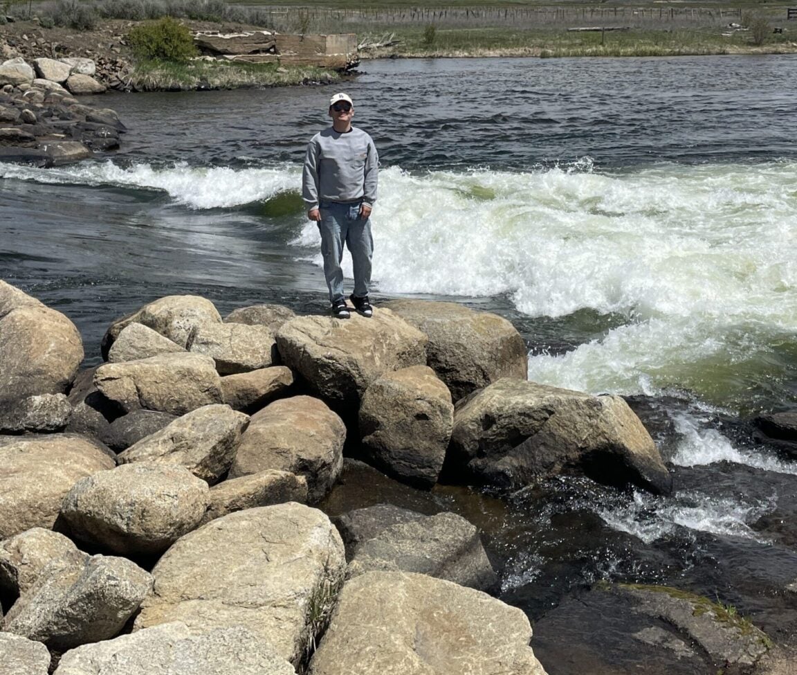 Zihao Zhang standing by a flowing river