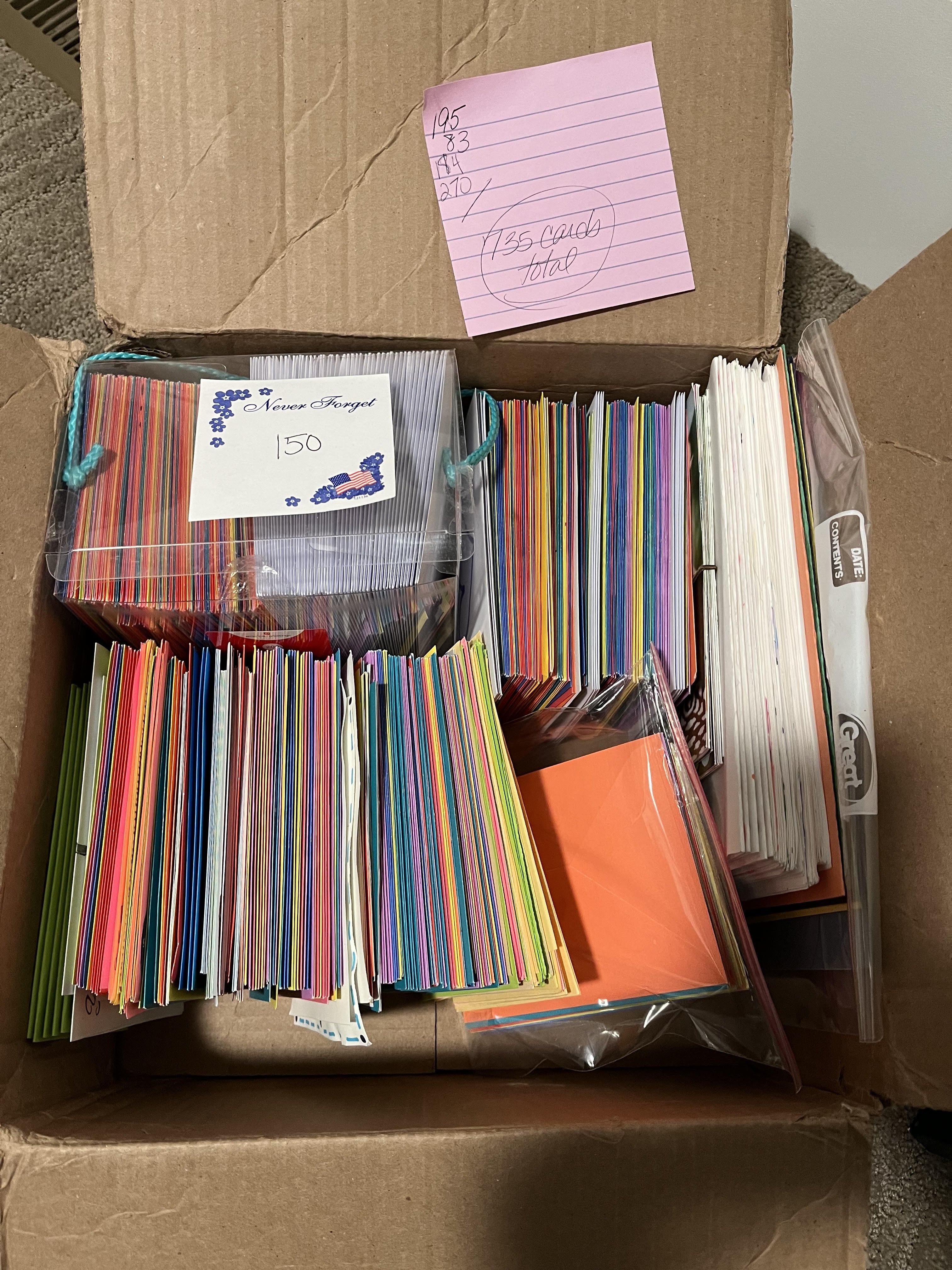 A photo of a cardboard box filled with 735 hand-drawn thank you cards in various colors and sizes.