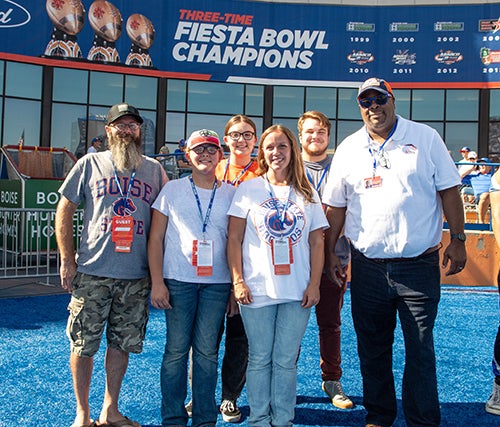 Stephanie Lewis with family and Dean James Satterfield on the blue turf at halftime