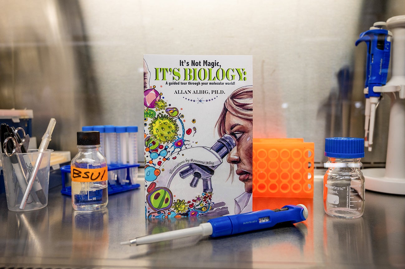 book sits on lab bench surrounded by lab equipment