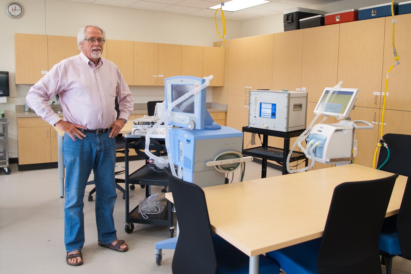 Respiratory Care faculty Lonny Ashworth stands in lab with ventilators
