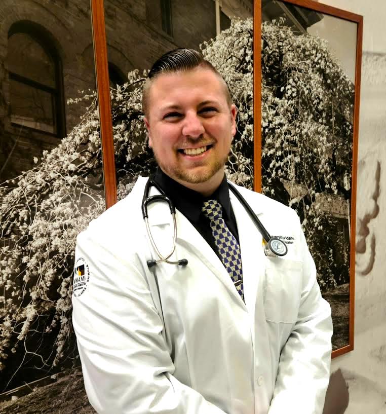 Cameron Skaggs, Boise State 2020 graduate, poses for a photo wearing a white lab coat and stethoscope around his neck