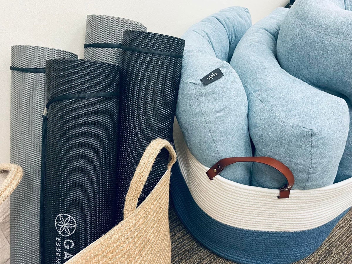 Yoga mats and meditation cushions in two baskets.