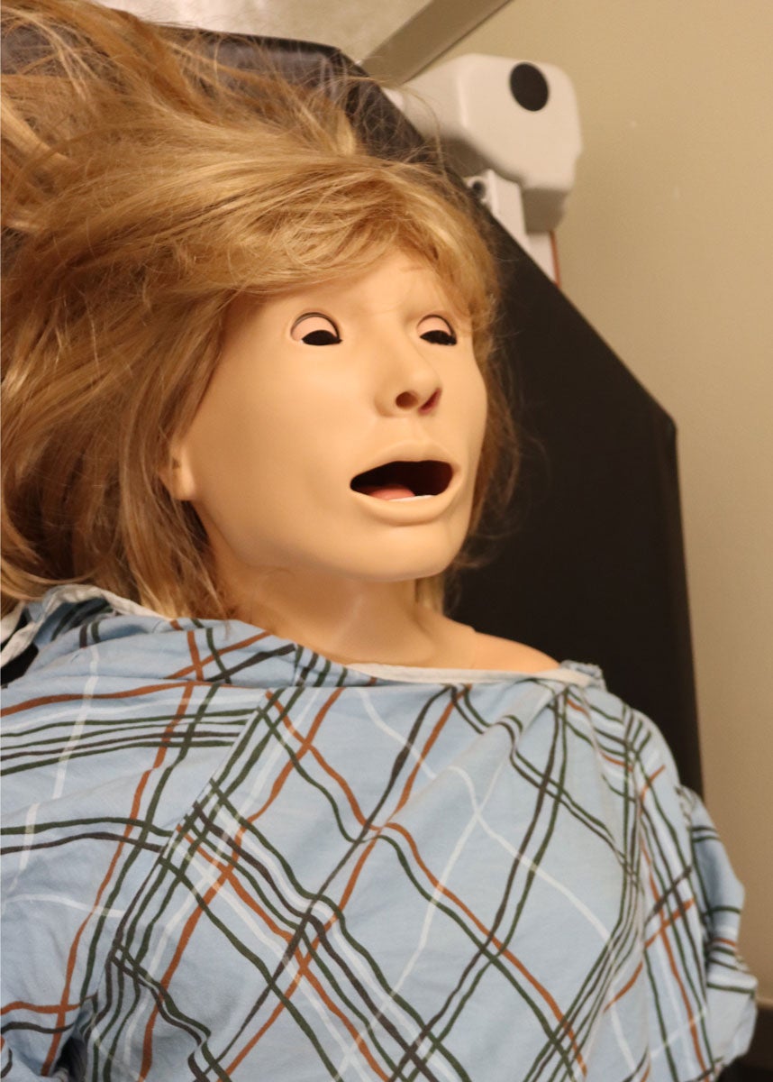 A Susie manikin lies with her mouth open.