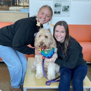 Peer Health Educators pose with therapy dog.